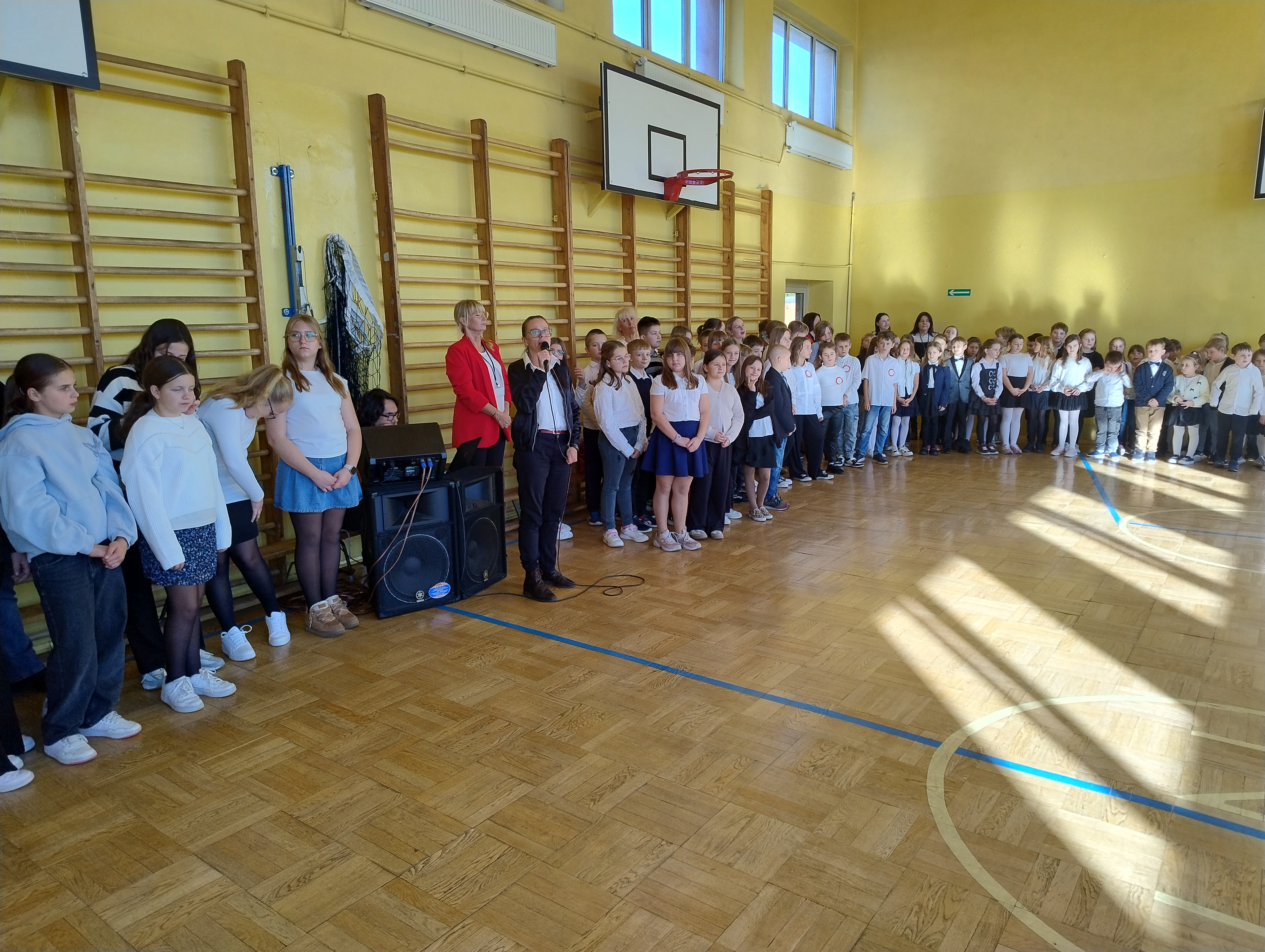 Uczniowie SP3 na&nbsp;sali iumnastycznej podczas śpiewania hymnu pańśtwowego