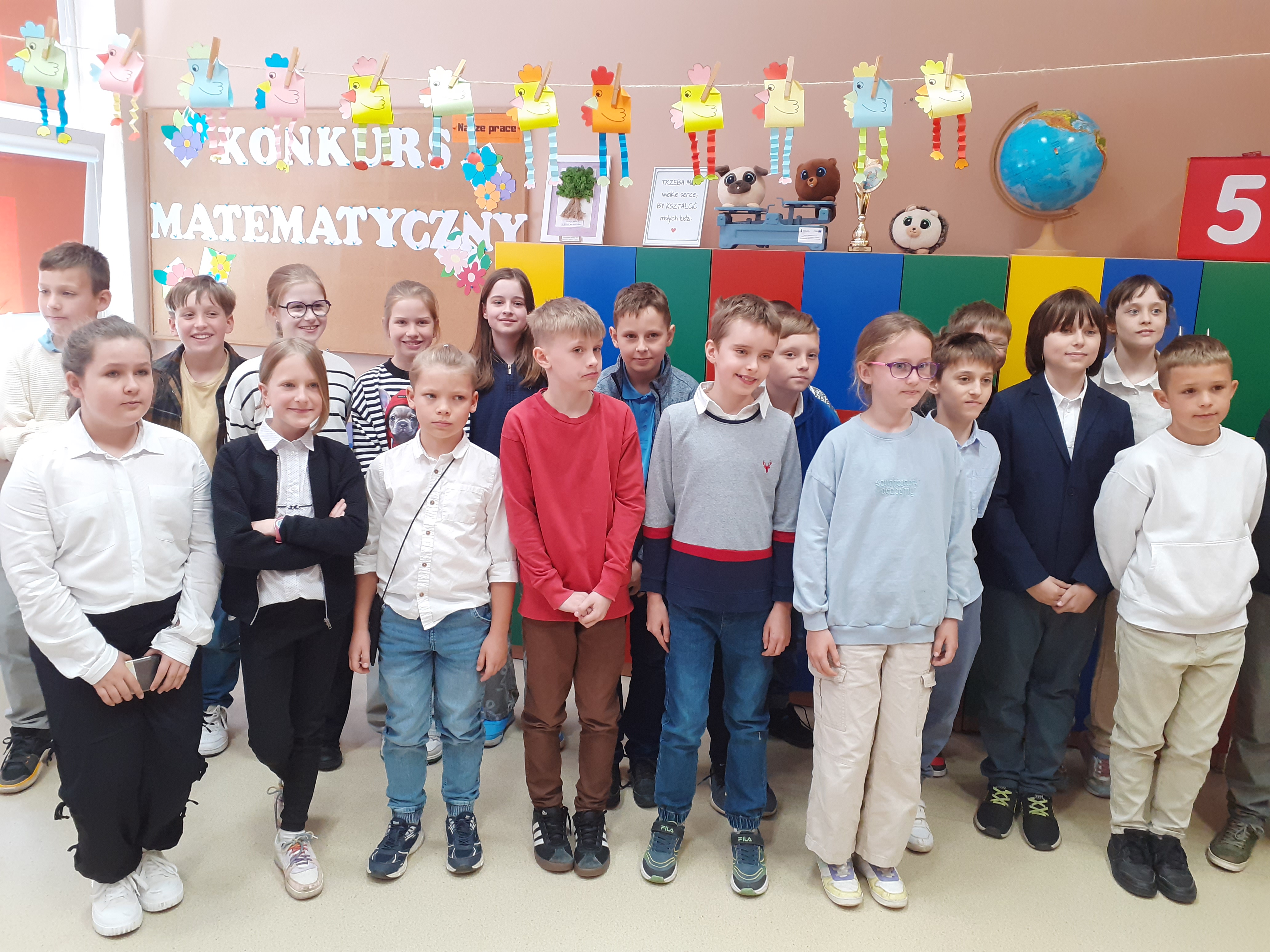 Uczniowie z&nbsp;długopisami i&nbsp;dyplomami na&nbsp;tle napisu "Konkurs Matematyczny"