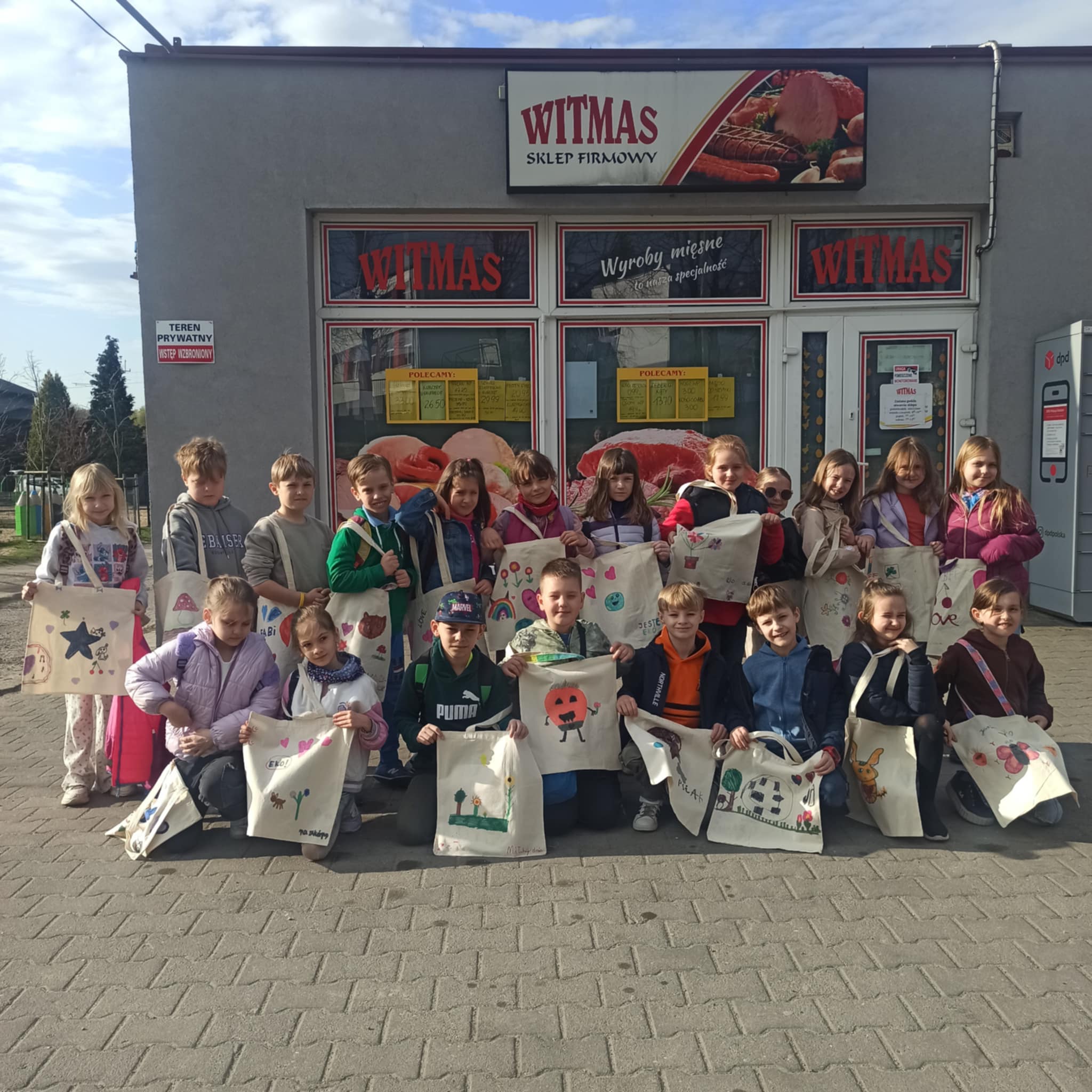 Grupa uczni&oacute;w prezentująca ekotorby 