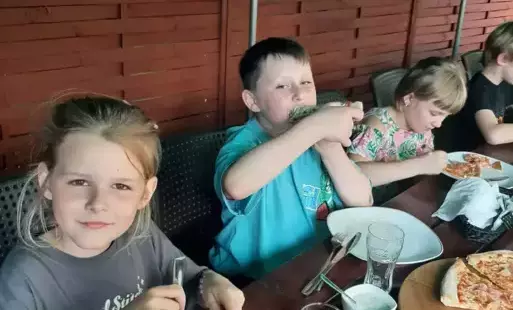 Uczniowie jedzący pizzę w pizzerii