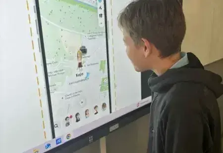 Uczeń rozwiązujący zadanie przy tablicy multimedialnej dotyczące cyberprzemocy