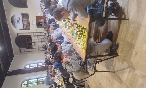 uczestnicy siedzący przy szachownicach podczas jednej z rund turniejowych, na pierwszym planie z lewej strony nasz wicemistrz Aleksy Kałużny